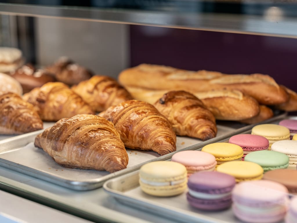 Croissant, baguette e macarons su vassoi da laboratorio